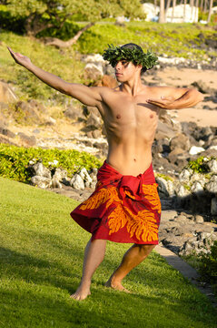 Male Hula Dancer on the grass by the beach.       