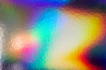 Colorful holographic iridescent holo bg texture, cold vs. warm, blue, yellow and red abstract background