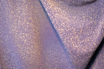 Draped lilac purple textile with golden sparkly glitter threads bg texture