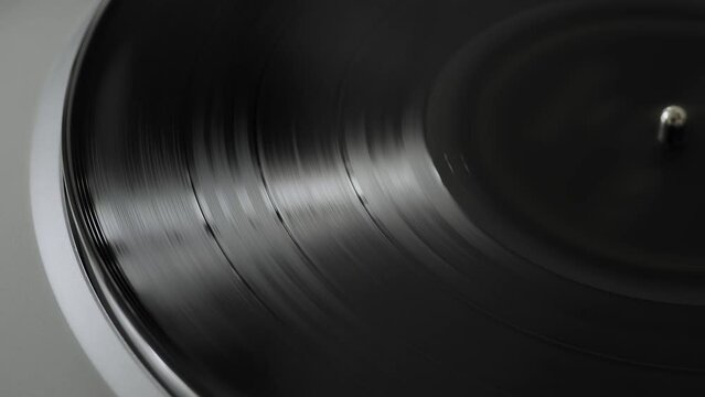 Close up of a silver modern vinyl turntable playing at home