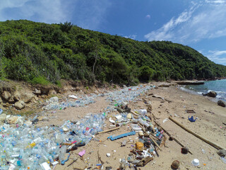 Garbage washed ashore. Plastic bottles and other rubbish thrown on the beach.