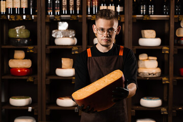Limited gouda cheese in hands of cheese sommelier. Snack tasty piece of cheese for appetizer.