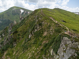 Fototapeta premium Panoramic aerial view of mountains in summer. Hiking destination. Alpine meadow