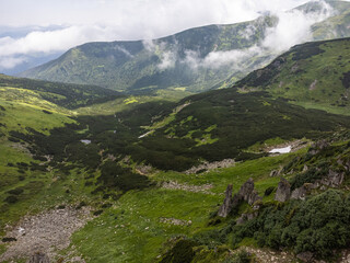 Fototapeta na wymiar Panoramic aerial view of mountains in summer. Hiking destination. Alpine meadow