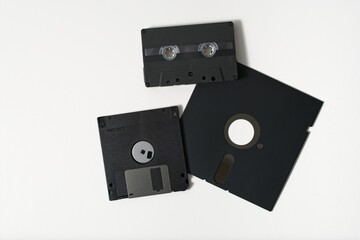 'Collection of vintage magnetic digital store media, represented by floppy disks and cassette tape'