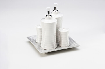 Grooved ceramic kitchen kit with 2 bottles for olive oil and vinegar, and two containers for salt and pepper, isolated on white