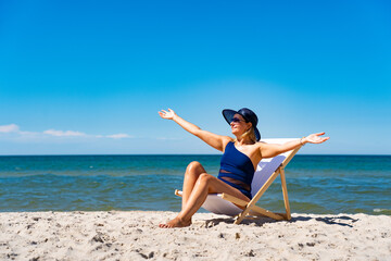 Woman relaxing on beach sitting on sunbed