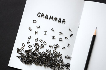 the word grammar is made from black english letters scattered on a clean white blank sheet, learning english - obrazy, fototapety, plakaty