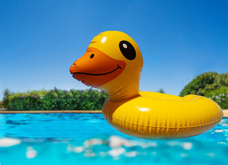 Close-up of Inflatable cute yellow duck swim in the pool