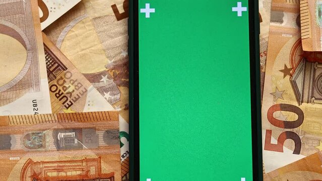 smartphone with green screen, chroma key phone on the background of 50 euro banknotes cash, the concept of online payment, shopping