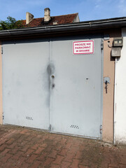 fixed metal garage door with a sign saying "please do not park in the gate"