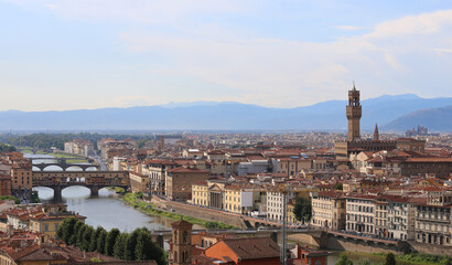 Fototapeta na wymiar Tower of Old Palace and Arno River with Ponte Vecchio that means OLD BRIDGE in Florence in Italy