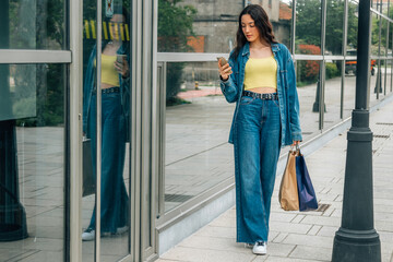 Obraz premium girl on the street shopping with mobile phone