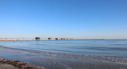 shore of the beach at low tide and the wooden houses called Trabucchi in the Italian language