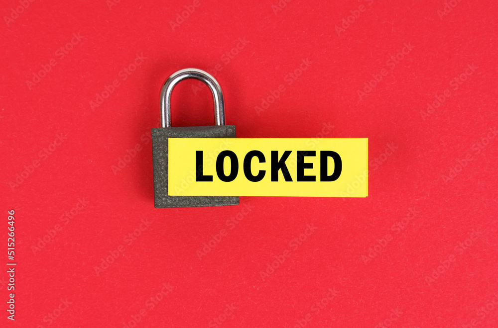 Poster on the red surface there is a lock with a sticker with the inscription - locked
