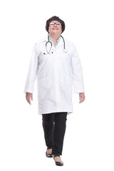 older female doctor with a stethoscope walks forward.