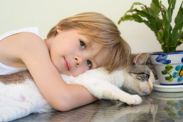 Portrait of adorable child boy with kitten outdoors.
