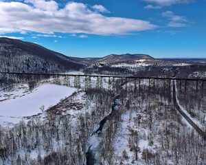 Aerial view of a snowy landscape with railroad tracks