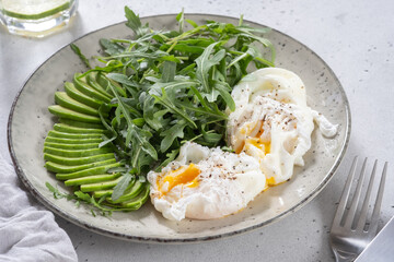 Healthy low carb breakfast. Poached eggs with avocado and arugula. Keto diet