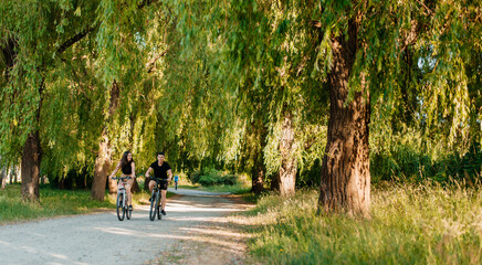 Fototapeta premium Young couple spend time riding bicycles together in the park