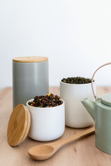 Fototapeta na wymiar Ceylon tea in mugs and jars on wooden table