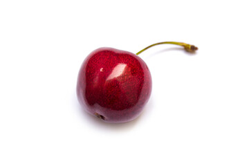 a red cherry lies on a white background