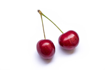 two twin cherries lie on a white background