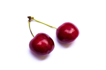two twin cherries lie on a white background
