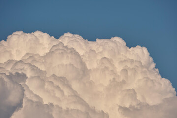 White puffy cumulus clouds on summer blue sky