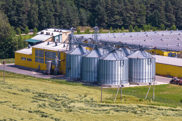Fototapeta na wymiar aerial view on silos and agro-industrial livestock complex on agro-processing and manufacturing plant with modern granary elevator. chicken farm. rows of chicken coop