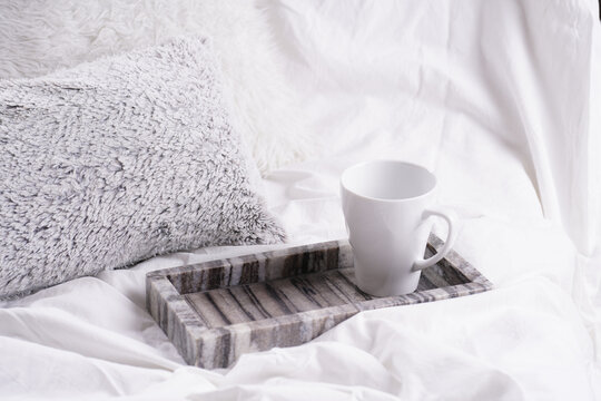 An Empty White Porcelain Cup For Coffee Or Tea In Grey Marble Tray On White Bed Sheets Among Fluffy Pillows - Breakfast In Bed