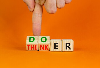 Doer or thinker symbol. Concept words Doer or thinker on wooden cubes. Businessman hand. Beautiful orange table orange background. Business and doer or thinker concept. Copy space.