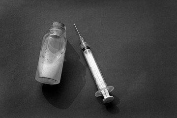 Syringe with vaccine bottle on dark background. Healthcare medicine with equipment. Vaccination...