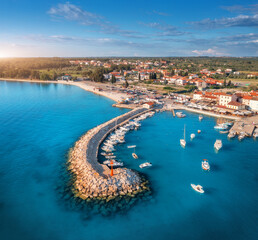 Aerial view of boats and luxure yachts in dock, breakwater, blue sea, old city at sunset in summer....