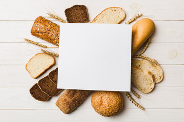 Minimalist paper blank mockup on background of Types of homemade bread. Different kinds of fresh bread as background, top view with space for your text or design