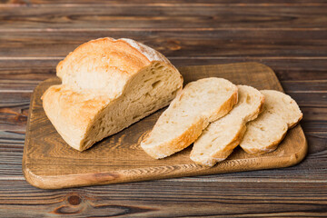 Assortment of freshly sliced baked bread with napkin on rustic table top view. Healthy unleavened bread. French bread slice