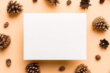 Creative frame made of Christmas pine cones with square Paper blank. Xmas and New Year theme. Flat lay, top view copy space