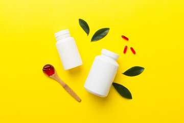 supplement pills with medicine bottle health care and medical top view. Vitamin tablets. Top view mockup bottle for pills and vitamins with green leaves, natural organic bio supplement, copy space