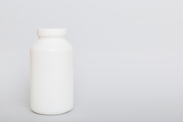 supplement pills with medicine bottle health care and medical top view. Vitamin tablets. Top view mockup bottle for pills and vitamins with green leaves, natural organic bio supplement, copy space