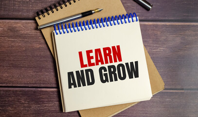 Learn and grow text on notepad and pen on wooden background