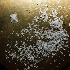 Maldon sea salt flakes with single pyramid shape salt crystal on hexagonal brass