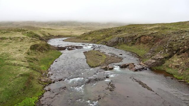 Fantastic landscape with flowing rivers and streams with rocks and grass in Iceland.