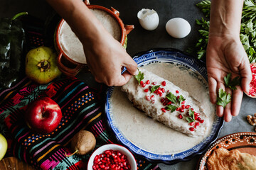 mexican woman hands preparing and cooking chiles en nogada recipe with Poblano chili and ingredients, traditional dish in Puebla Mexico - obrazy, fototapety, plakaty