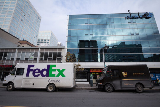 OTTAWA CANADA - NOVEMBER 12, 2018: Fedex & UPS logos on delivery vans next to each other in Ottawa street, Ontario. Fedex & UPS are competing American courier specialized in parcels & letters shipping