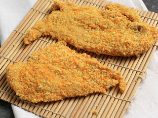 Breaded Chicken Cutlet or Chicken Katsu over a Bamboo Board with Breadcrumbs