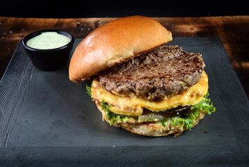 beef burger with bacon french fries cheese salad served with brioche bun