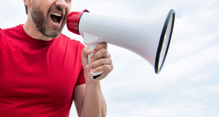cropped view of man in red shirt shout in loudspeaker on sky background