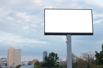 Large billboard on an iron pole against the backdrop of the city sky.