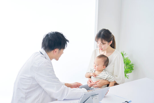 赤ちゃんを診察する医者