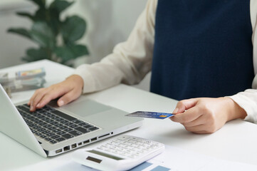 Woman hold credit card and using laptop computer. Online shopping concept.		